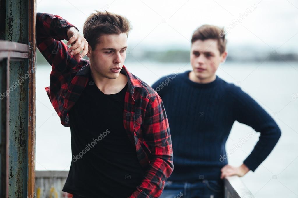 two guys stand in an abandoned building on lake