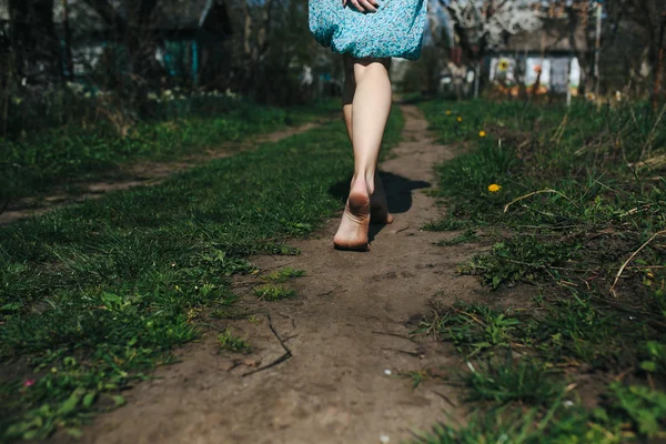 Beautiful girl legs follows a country road — Stock Photo, Image