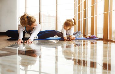 Anne ve kızı spor salonunda yoga yapmak