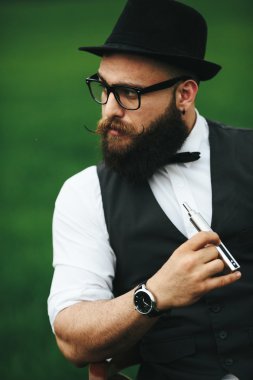 bir sakallı adam elektronik sigara içiyor