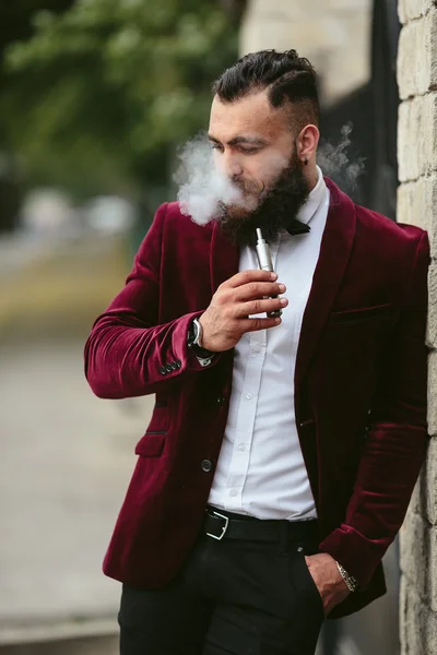 Hombre rico con barba fuma cigarrillo electrónico —  Fotos de Stock