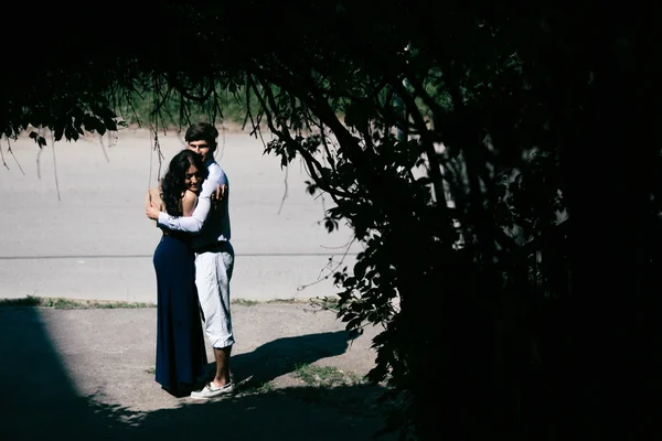 Casal pulando no final do túnel com árvores — Fotografia de Stock