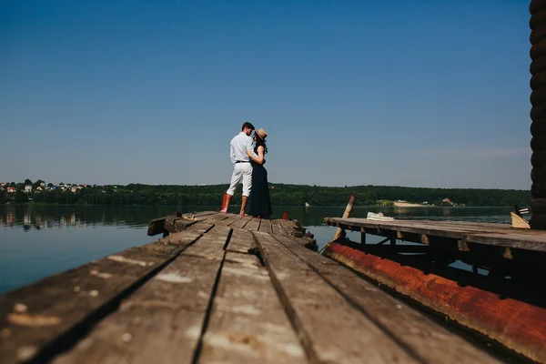 Hugging man and woman in love on wooden pier — Stock Photo, Image