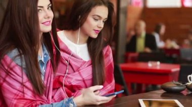 İki kız bir akıllı telefon ile müzik dinleme