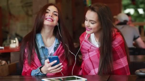 İki kız bir akıllı telefon ile müzik dinleme — Stok video