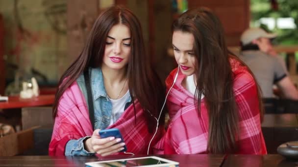 Δύο κορίτσι ακούγοντας μουσική με ένα smartphone — Αρχείο Βίντεο