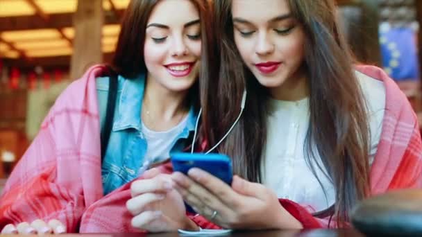 Две девушки слушают музыку со смартфона — стоковое видео