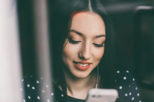 Schönes Mädchen, das mit Kopfhörern Musik am Telefon hört — Stockfoto