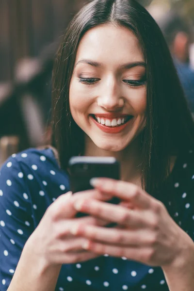 Schöne Mädchen tippt SMS auf dem Telefon — Stockfoto