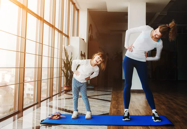 Twee meisjes van verschillende leeftijden maken van yoga — Stockfoto