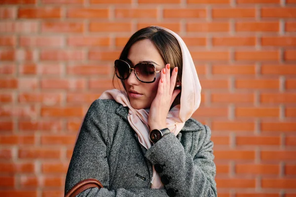 Girl posing on a background of red brick wall — Stock Photo, Image