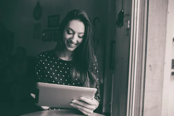 Krásná dívka pracuje na tabletu a usmívá se — Stock fotografie