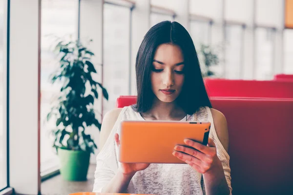 Schönes Mädchen, das an einem Tablet arbeitet und lächelt — Stockfoto