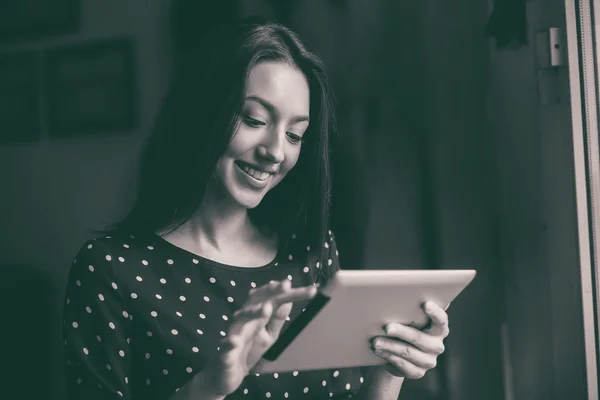 Schönes Mädchen, das an einem Tablet arbeitet und lächelt — Stockfoto