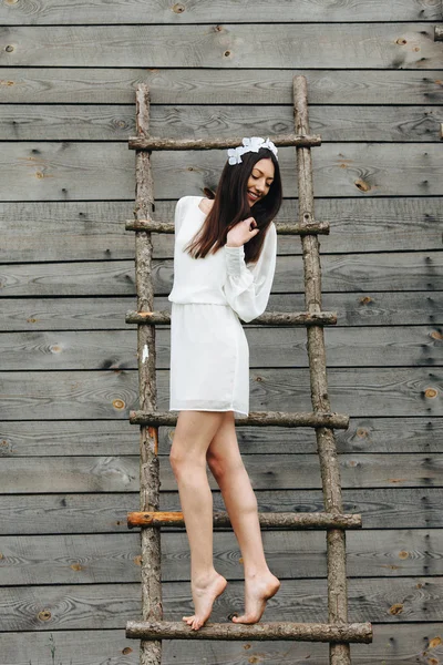 Girl climbing ladder into tree house — Stock Photo, Image