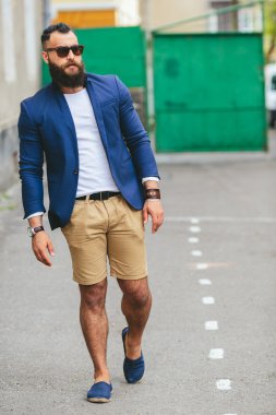 Şık sakallı adam şehirde yürüyor.