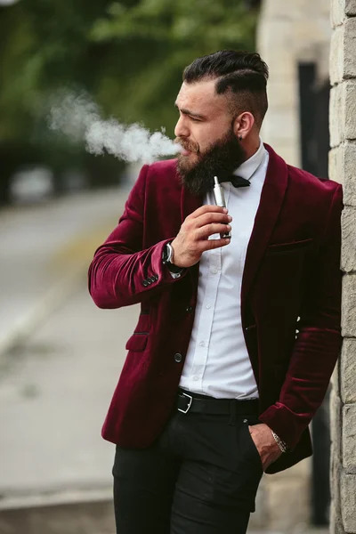 Hombre rico con barba fuma cigarrillo electrónico —  Fotos de Stock