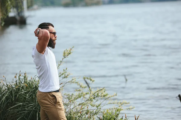 Amerikansk skæg mand ser på flodbredden - Stock-foto