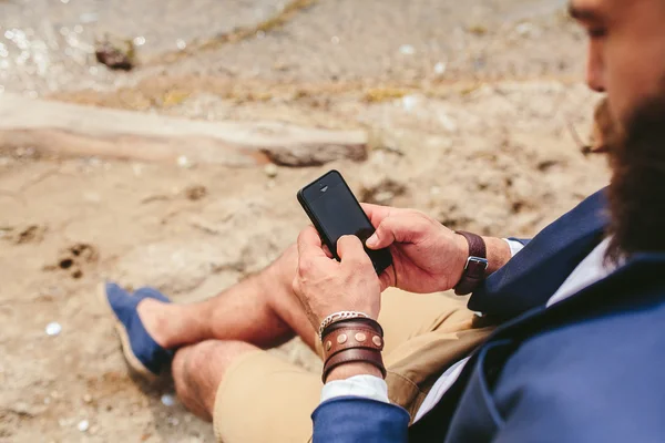 Американський бородатий людина за допомогою телефону біля річки — стокове фото