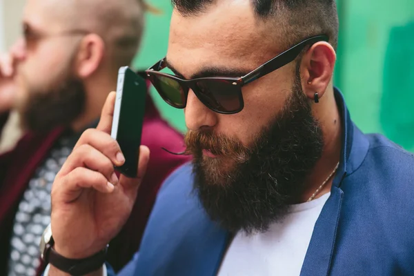 Dos hombres de negocios barbudos mirando el teléfono —  Fotos de Stock