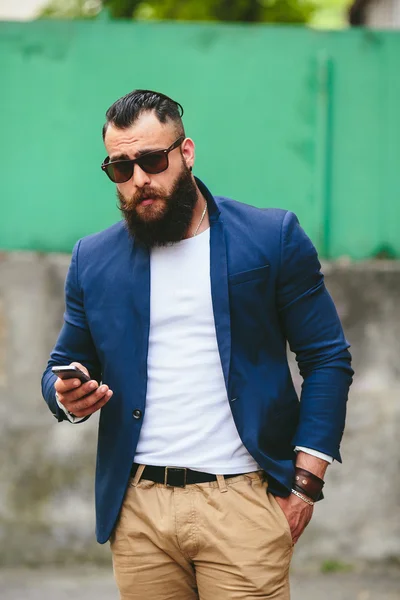 ひげを生やしたビジネスマンの携帯電話を見て — ストック写真