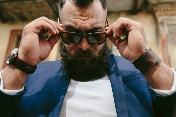 Stylish cool bearded man takes off his glasses — Stock Photo, Image