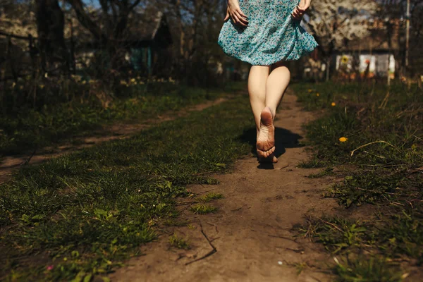 Beautiful girl legs follows a country road — Stock Photo, Image