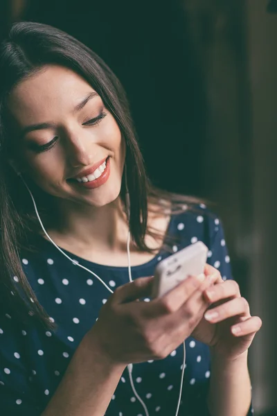 Güzel kız telefonda kulaklık ile müzik dinlemek — Stok fotoğraf