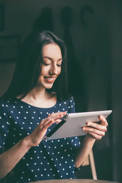 Schönes Mädchen, das an einem Tablet arbeitet und lächelt — Stockfoto