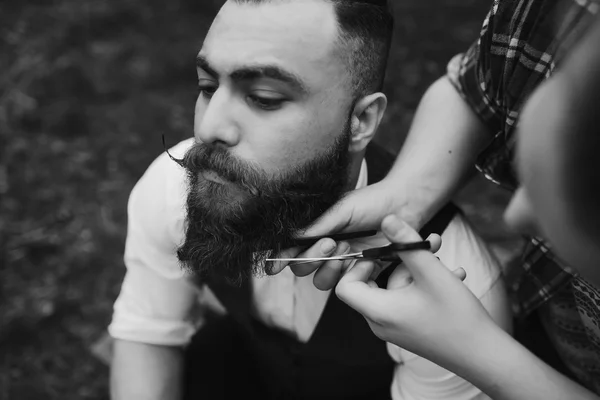 Barbero afeita a un hombre barbudo — Foto de Stock
