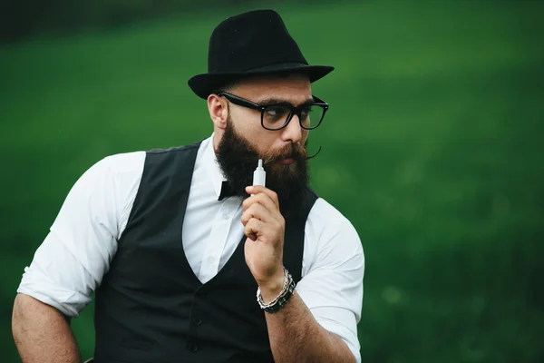 Homem com barba fuma cigarro eletrônico — Fotografia de Stock