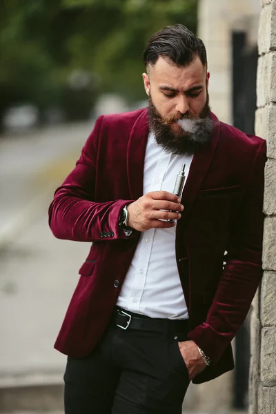 Rich man with a beard smokes electronic cigarette — Stock Photo, Image