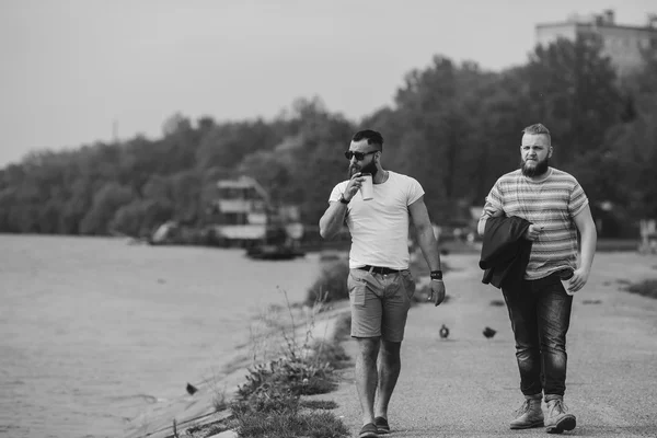 Dois homens caminham e bebem café — Fotografia de Stock