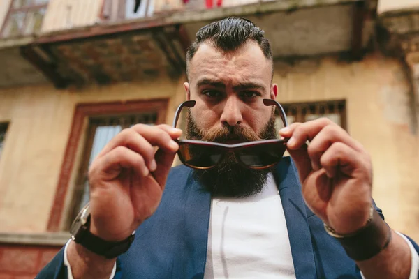 Elegante hombre barbudo fresco se quita las gafas —  Fotos de Stock