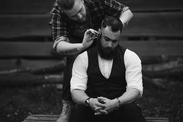 Barbiere radere un uomo barbuto — Foto Stock