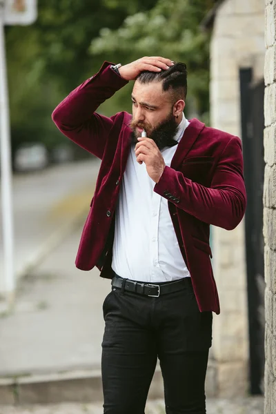 Rich man with a beard smokes electronic cigarette — Stock Photo, Image