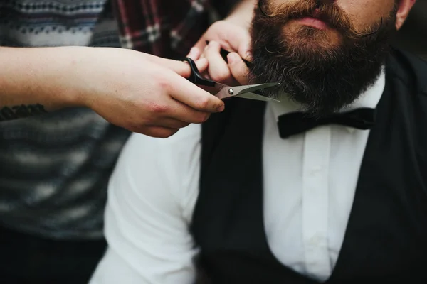 Barbero afeita a un hombre barbudo — Foto de Stock