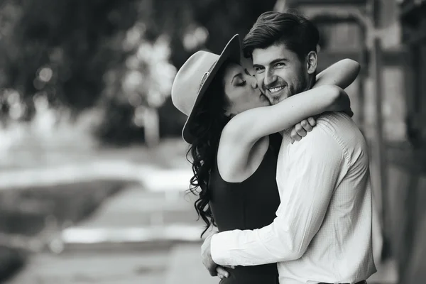 Beautiful girl embraces and kisses her boyfriend — Stock Photo, Image