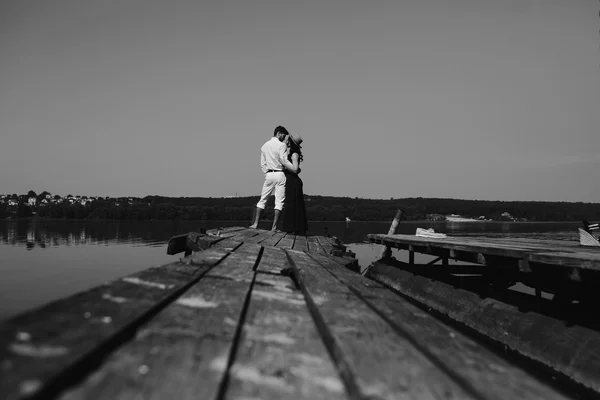 Abraçando homem e mulher apaixonados no cais de madeira — Fotografia de Stock