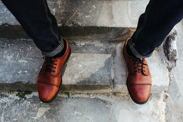 Fötter av män i sömmen jeans och retro skor — Stockfoto