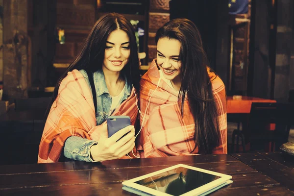 Dos chicas sentadas escuchando música con — Foto de Stock