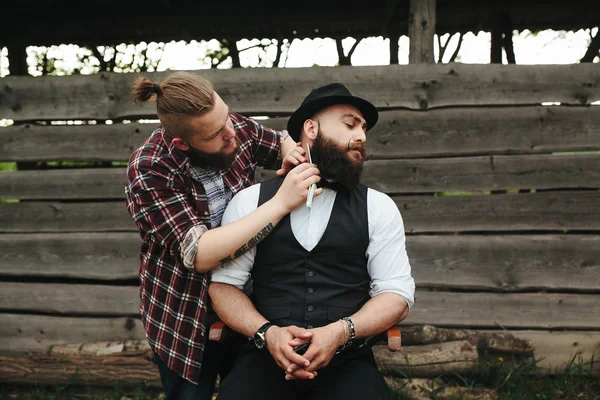 Holič holí vousatý muž — Stock fotografie