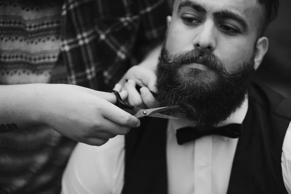 Barbeiro barba um homem barbudo — Fotografia de Stock