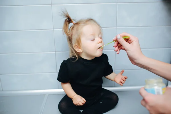 Mãe alimenta sua filha com uma colher — Fotografia de Stock