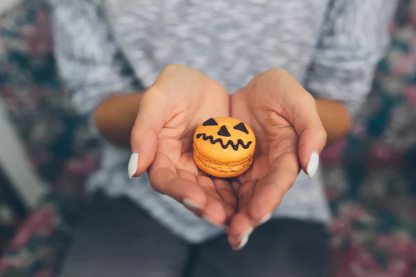 Woman sitting and holding a cookie — Stock Photo, Image