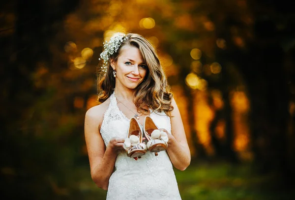 Noiva segurando sapatos de casamento — Fotografia de Stock