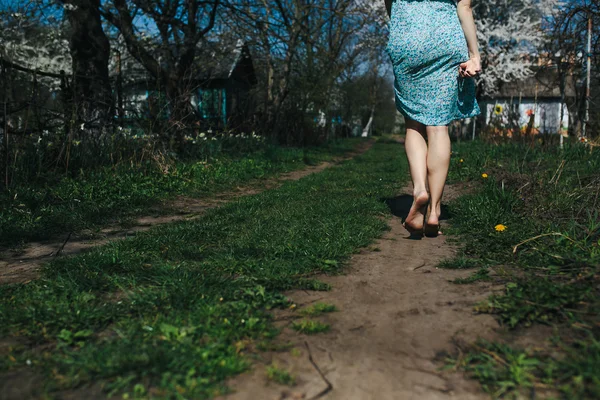 Ноги девочки идут по проселочной дороге — стоковое фото
