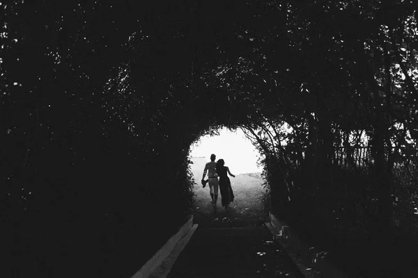 Couple walking through the tunnel of trees — Stock Photo, Image