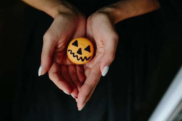 Woman holding a biscuit for Halloween — Stock Photo, Image