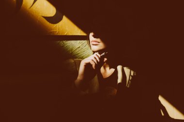 Kız oturur ve elektronik sigara içiyor